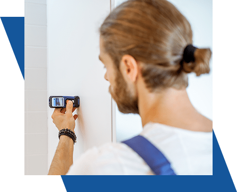 Man using a digital device to measure a wall.