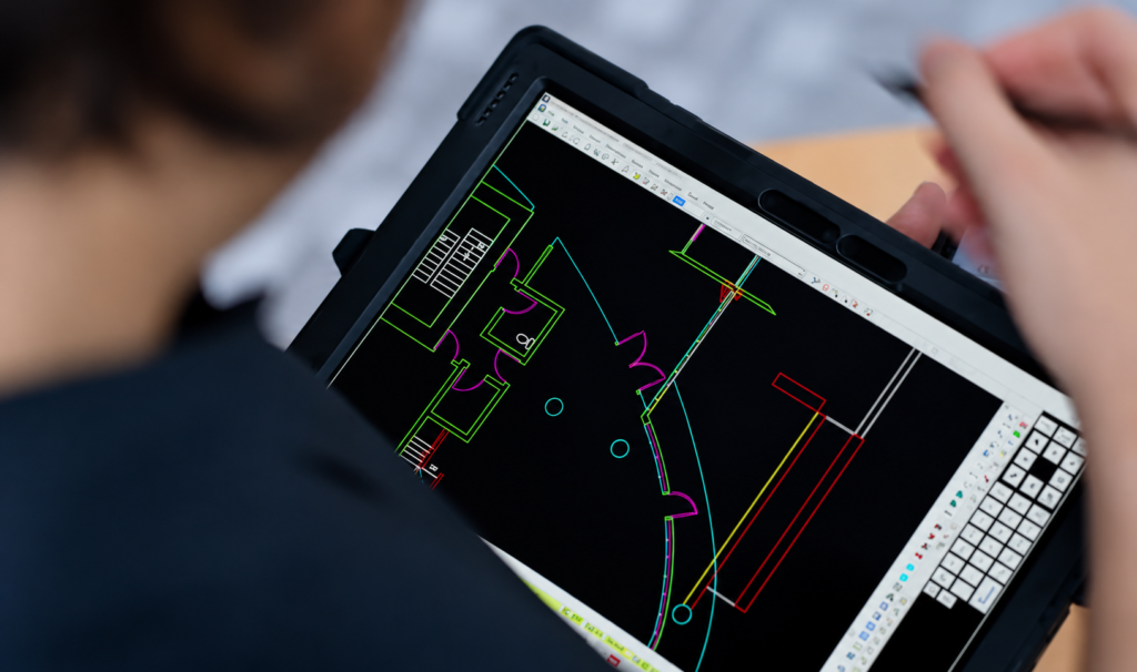 A person uses a digital pen to edit a floor plan on a tablet screen.